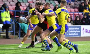 Widnes Vikings forward Rhodri Lloyd offloads the ball against Warrington Wolves in the Challenge Cup